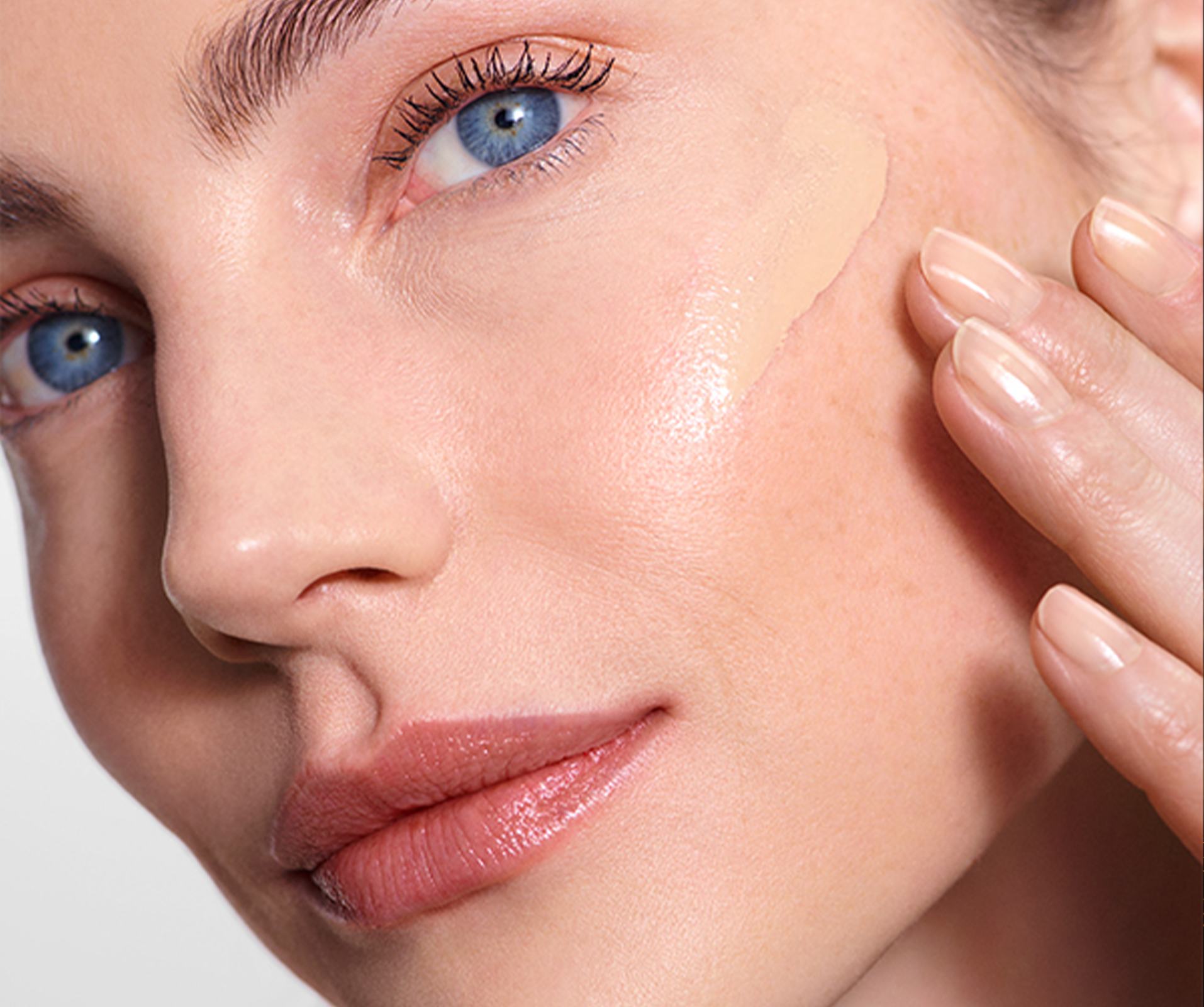 a woman applying foundation on her face