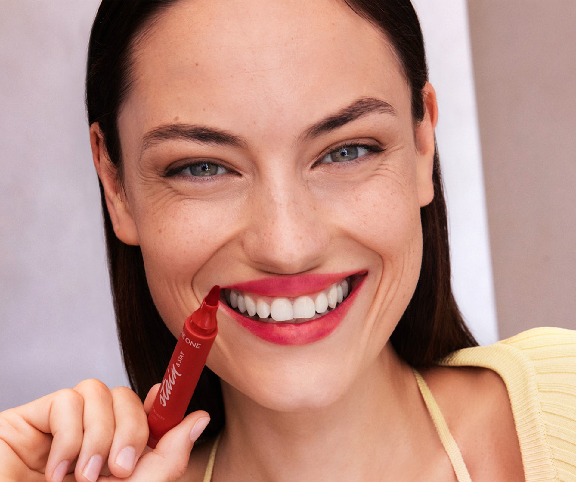a woman smiling with a red lip liner