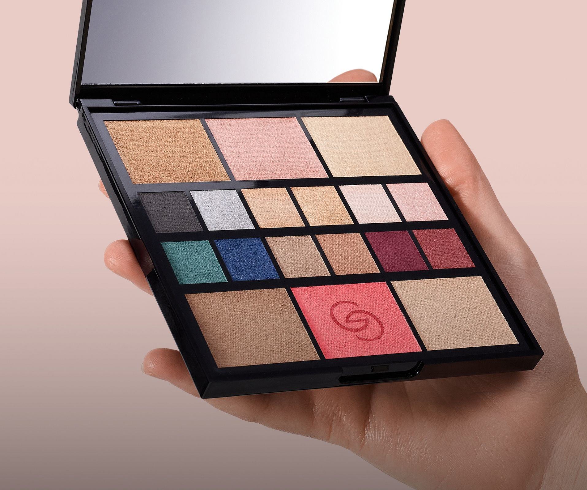 a hand holding a makeup palette