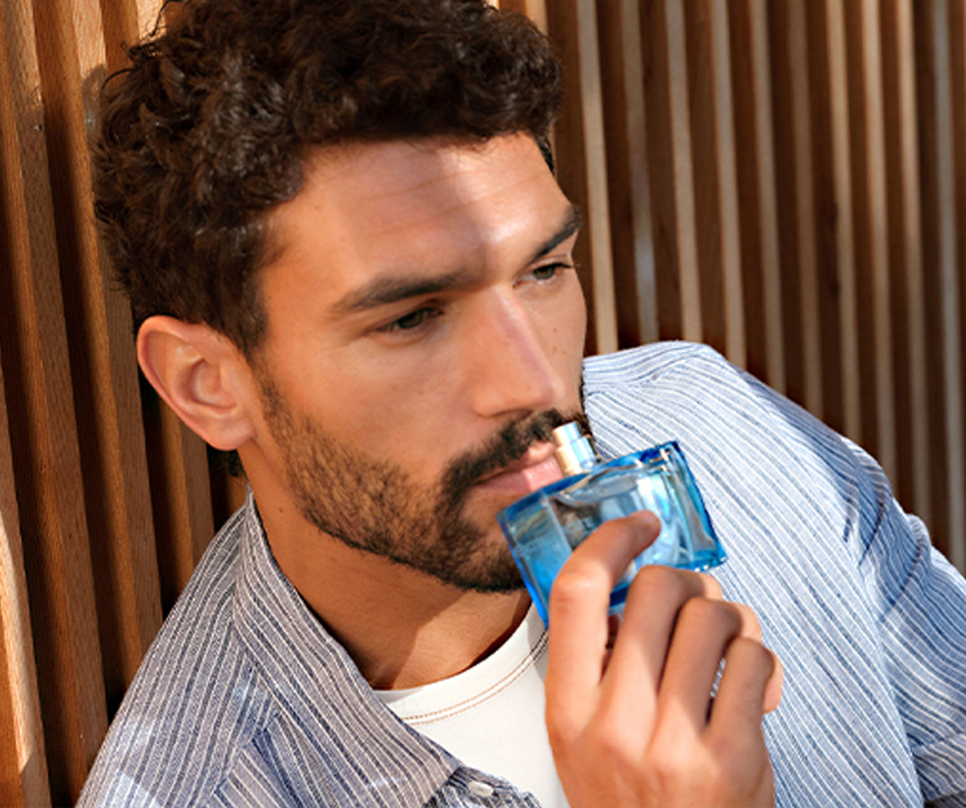 um homem a segurar um frasco de perfume