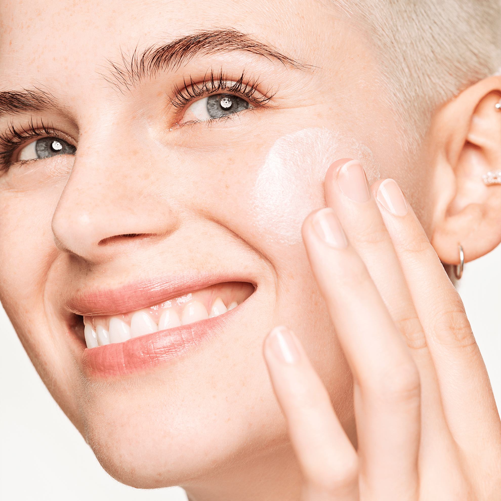 a woman applying a cream on her face