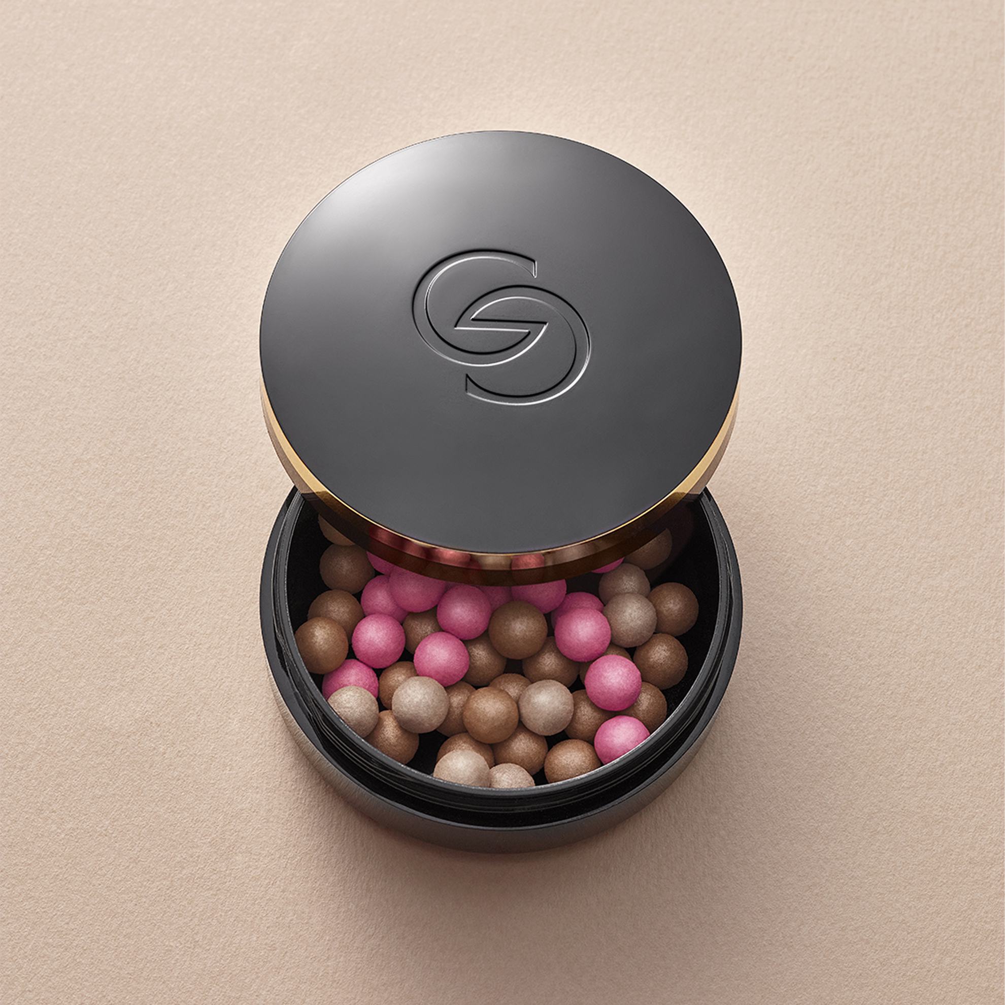 a black container with a black lid filled with pink and brown balls