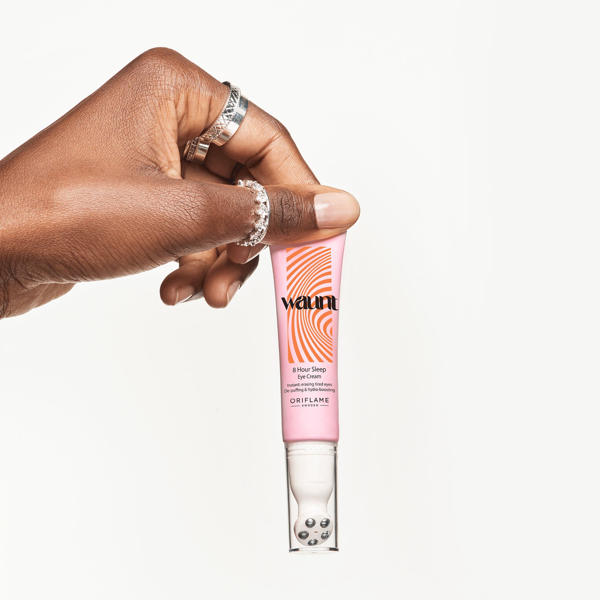 a hand holding a tube of cream