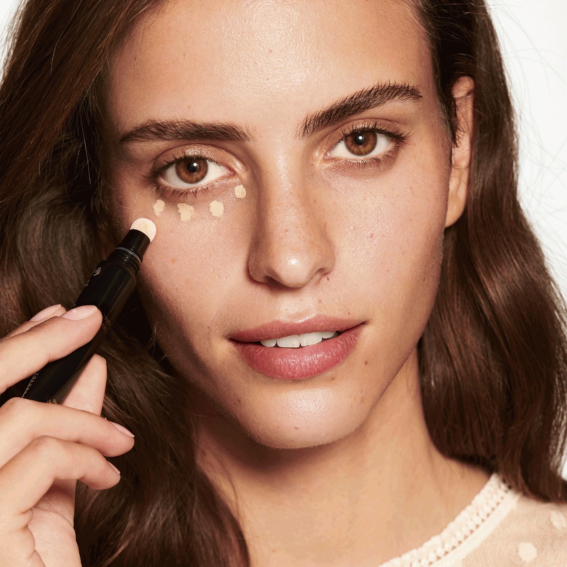 a woman applying foundation on her face