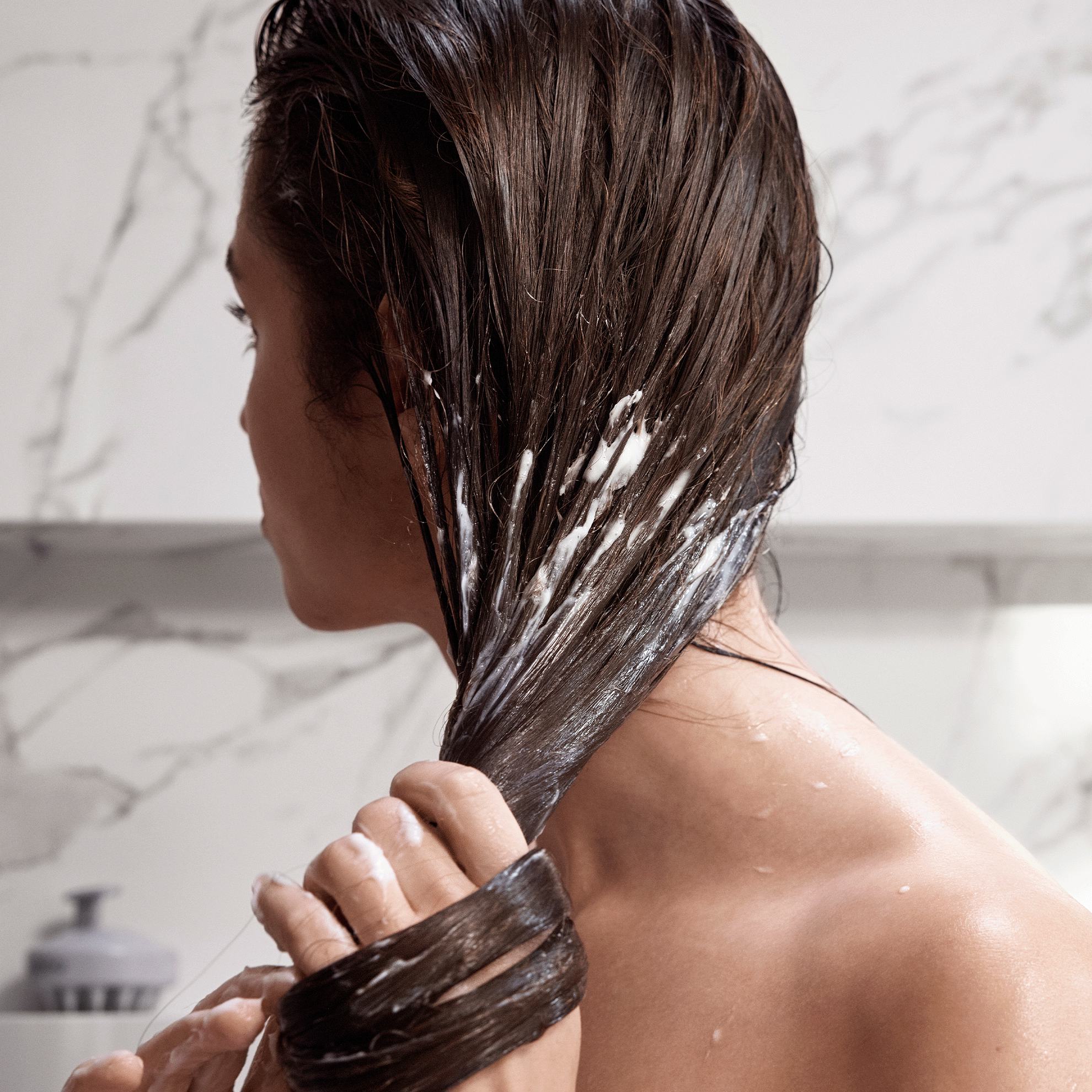 Una mujer lavándose el pelo.