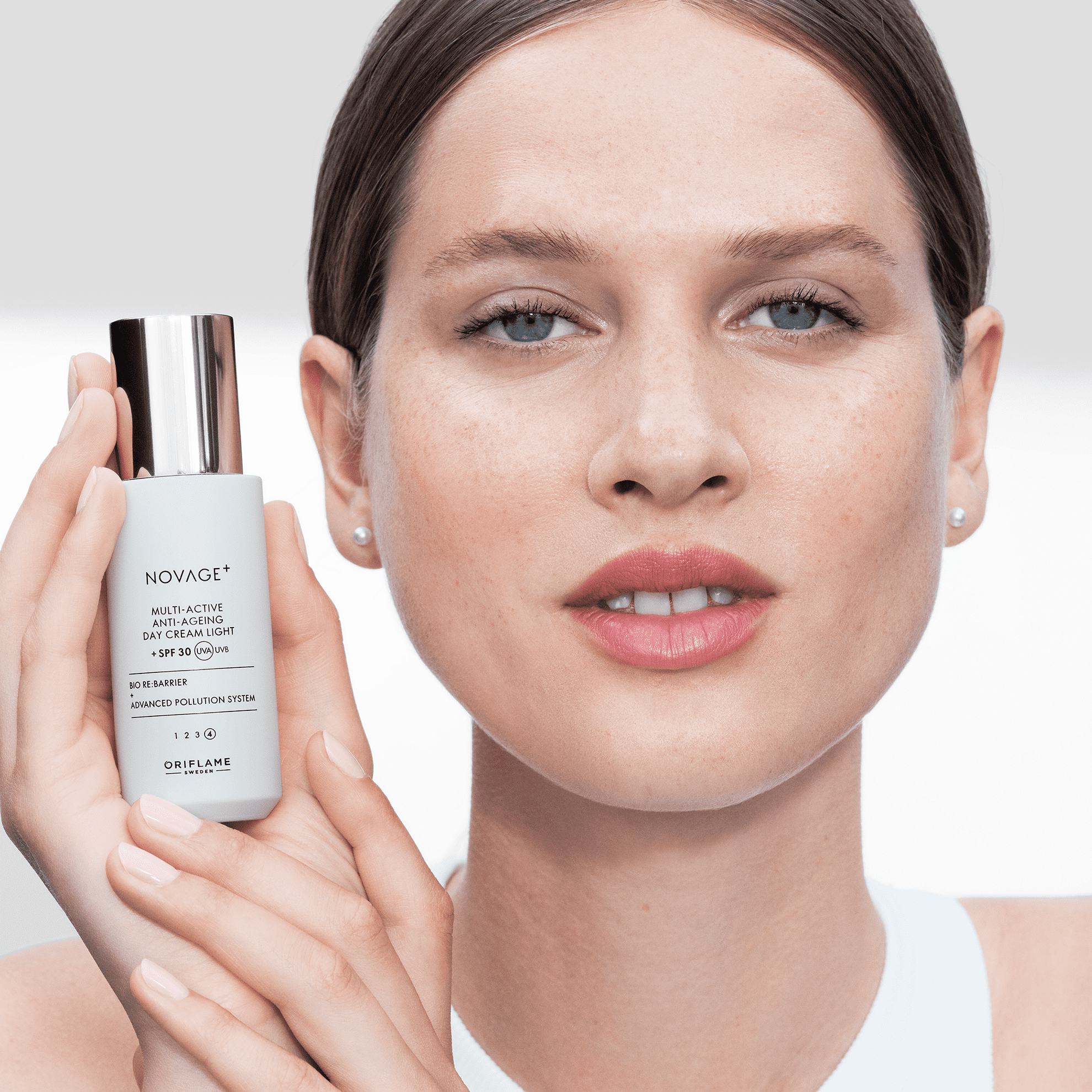 bir shisha terini parvarish qilish mahsulotini ushlab turgan ayol