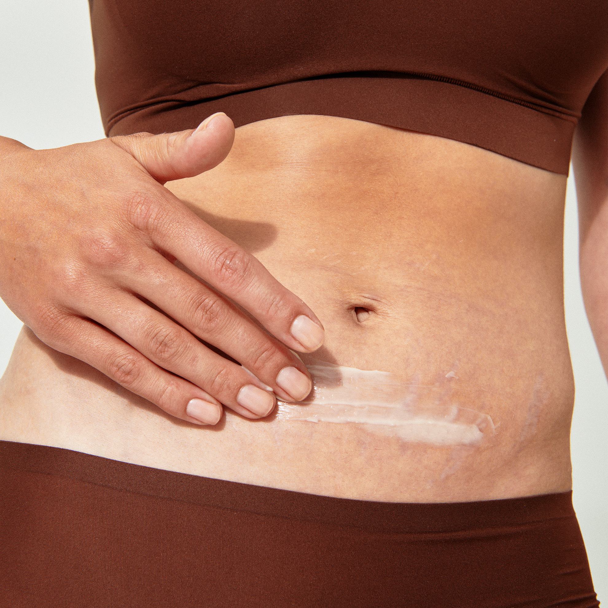 El vientre de una mujer con crema.