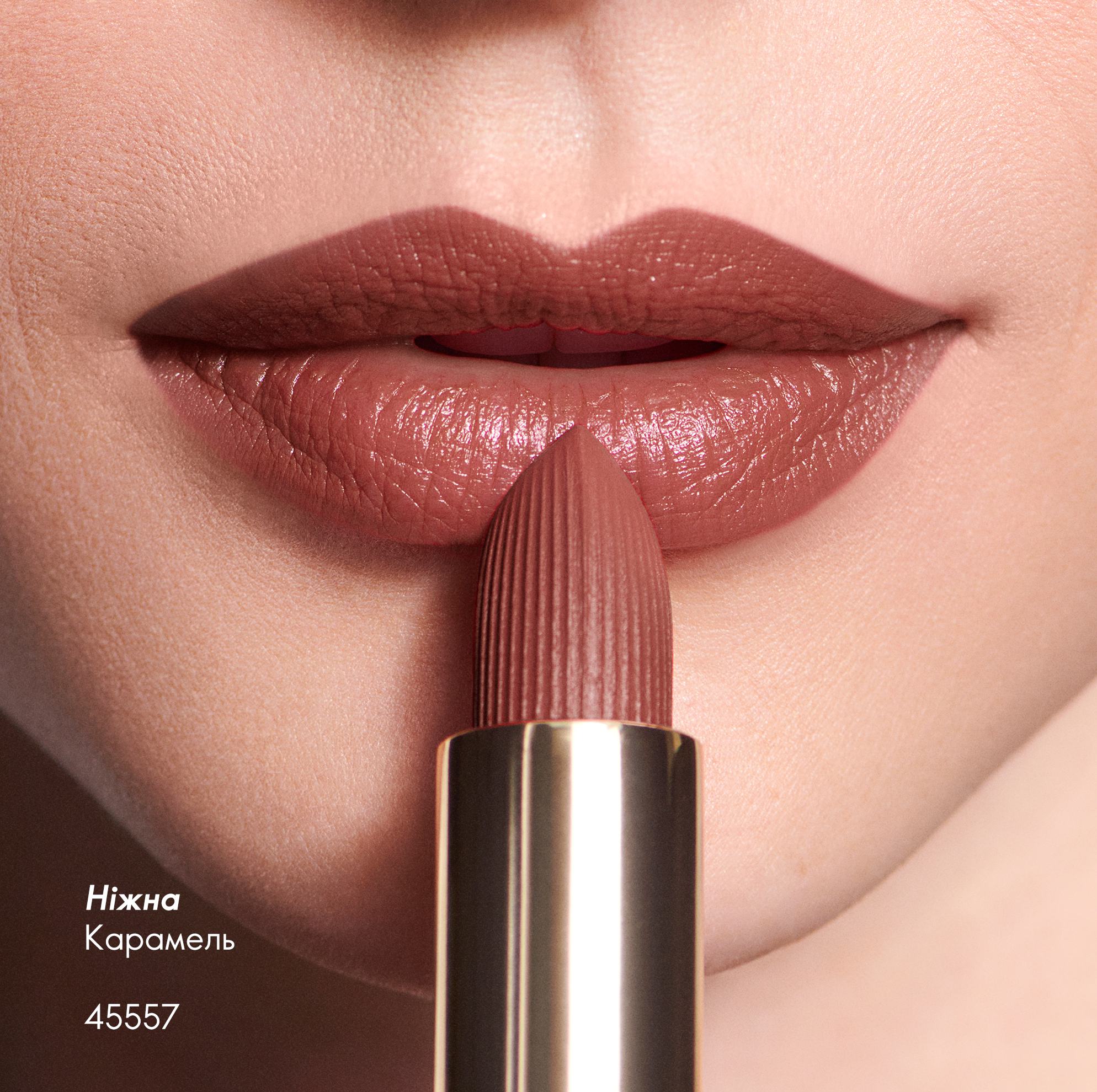 жінка наносить помаду на губи