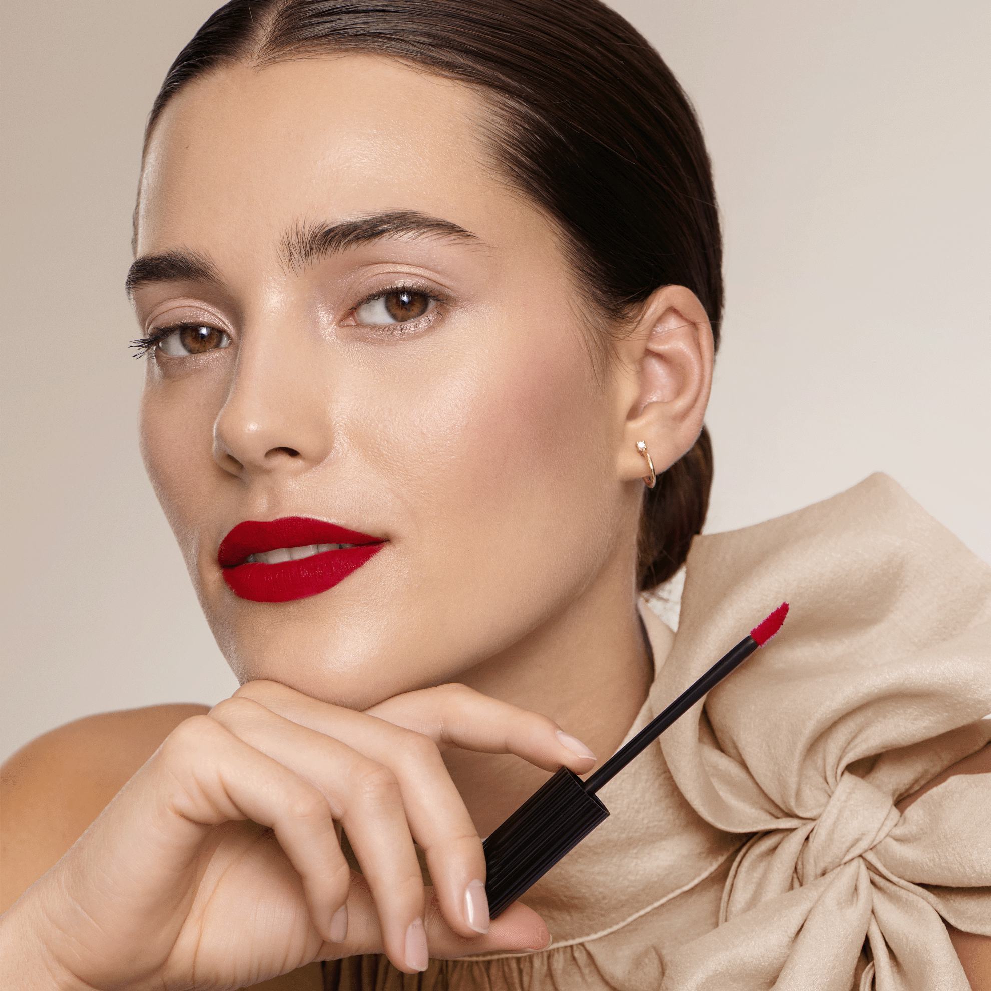 žena koja drži sjaj za usne