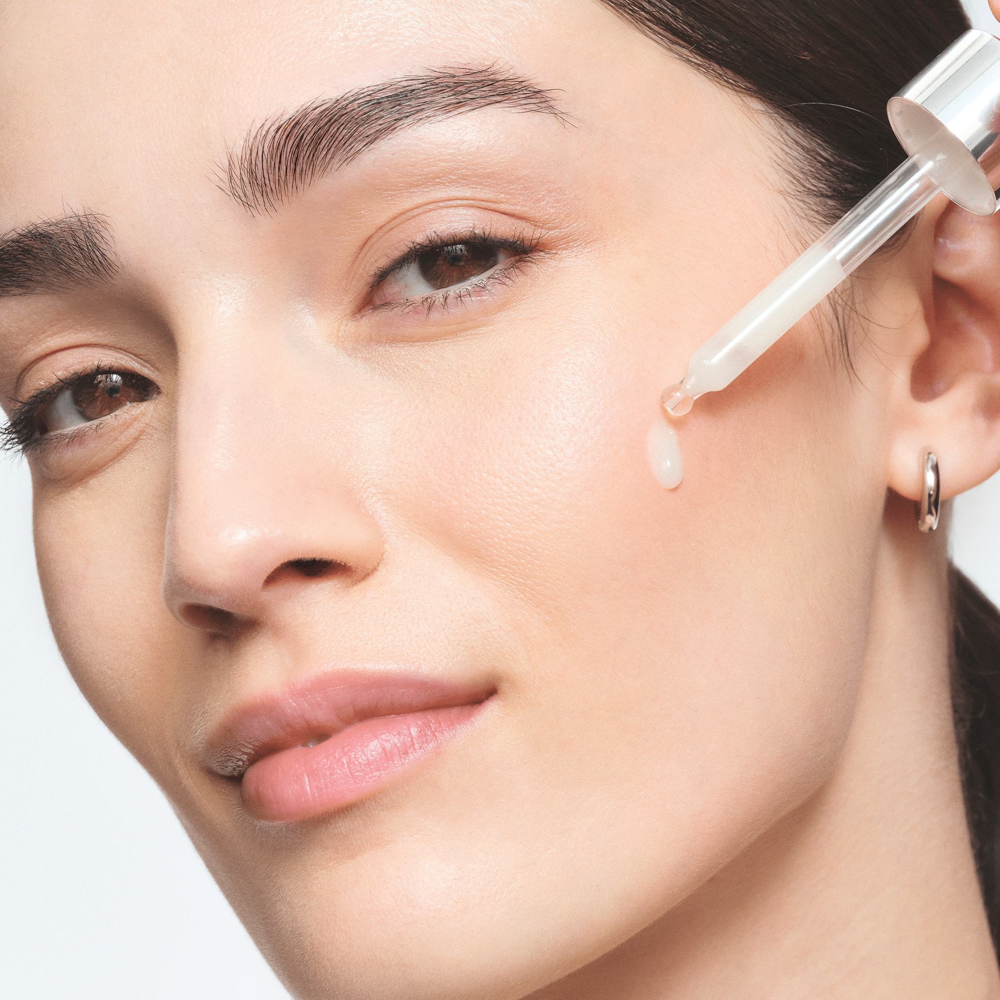 sieviete, kas uzklāj pilinātāju uz sejas