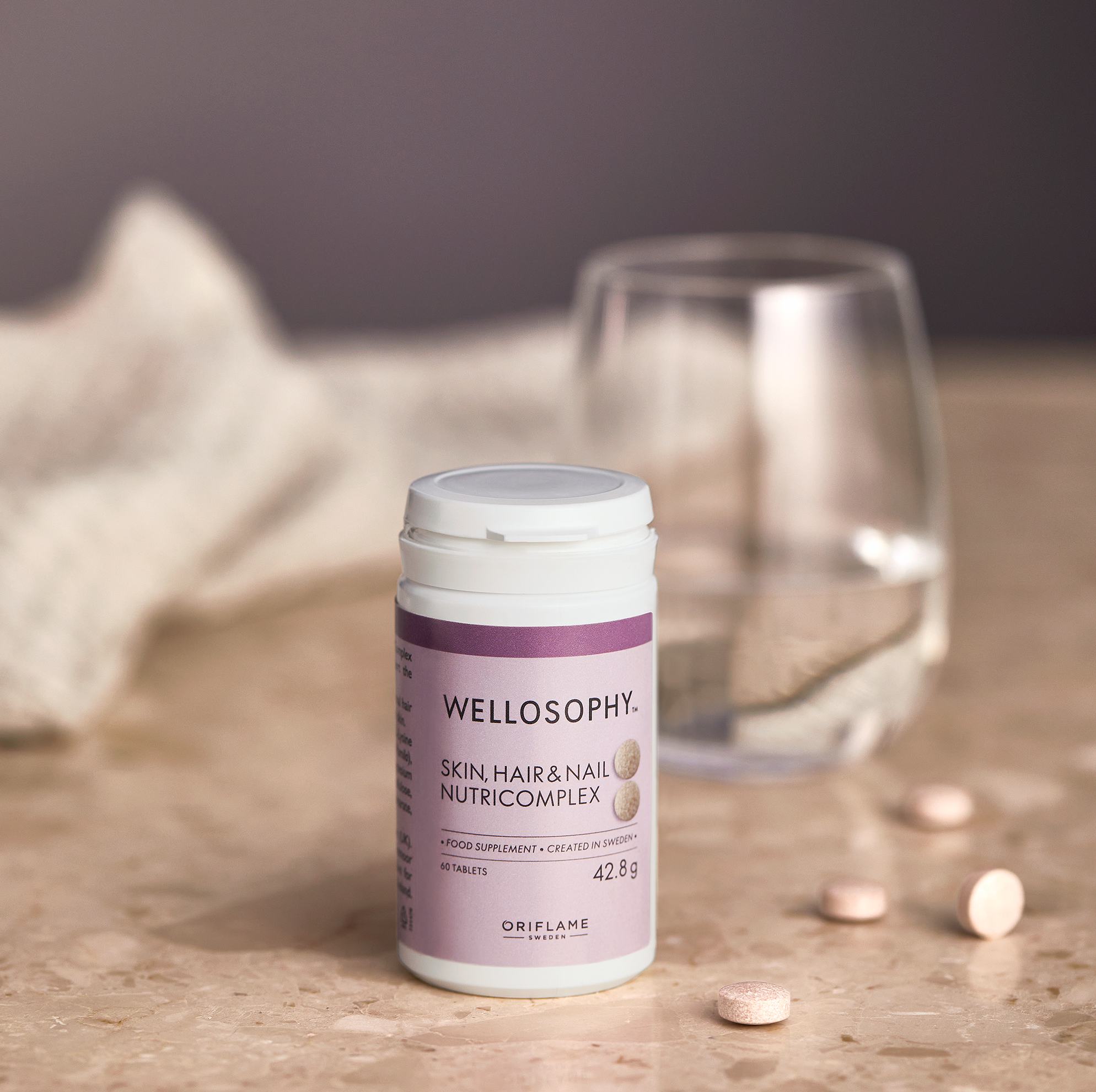 vitamīnu pudele blakus glāzei ūdens