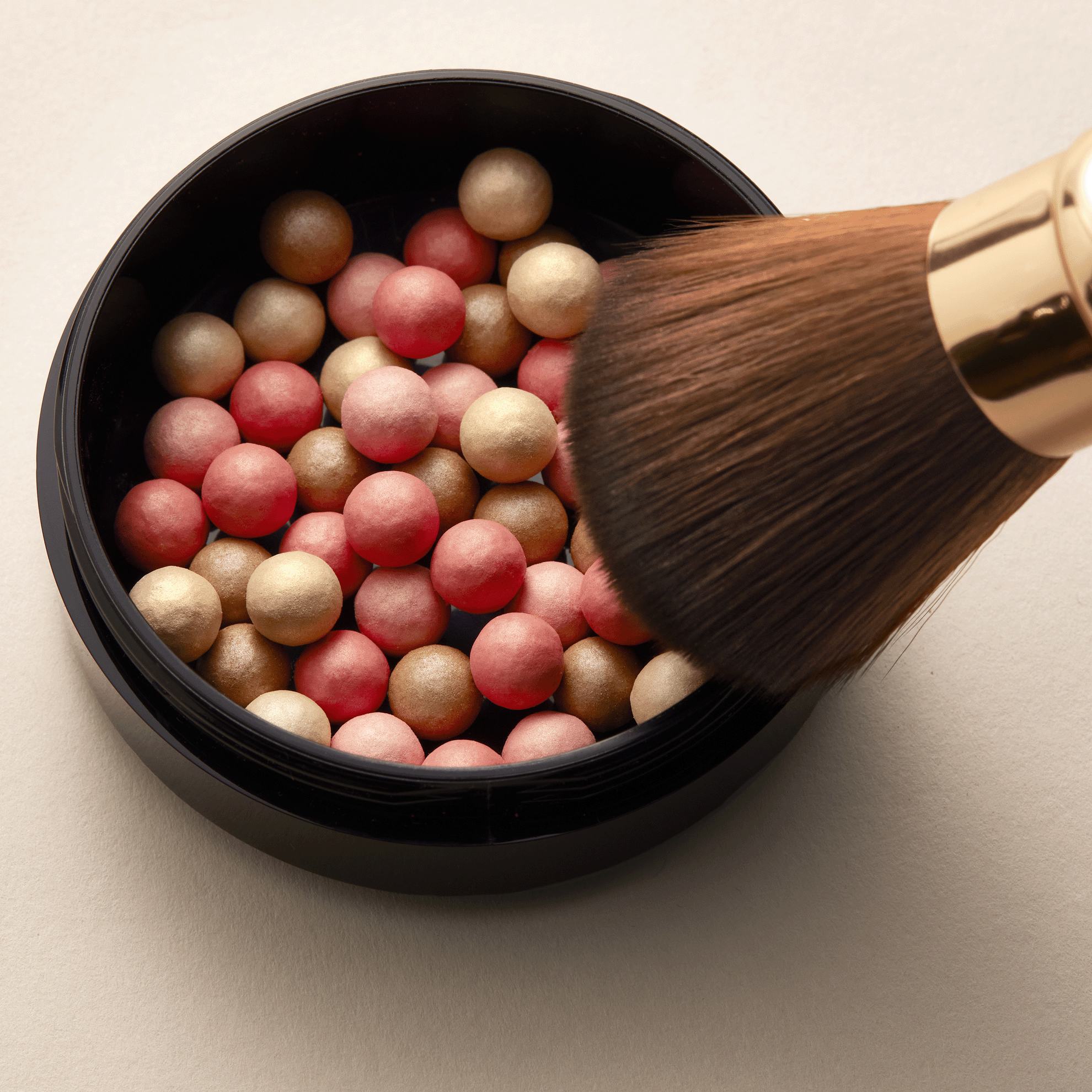 o pensulă cu un recipient rotund de fard de obraz