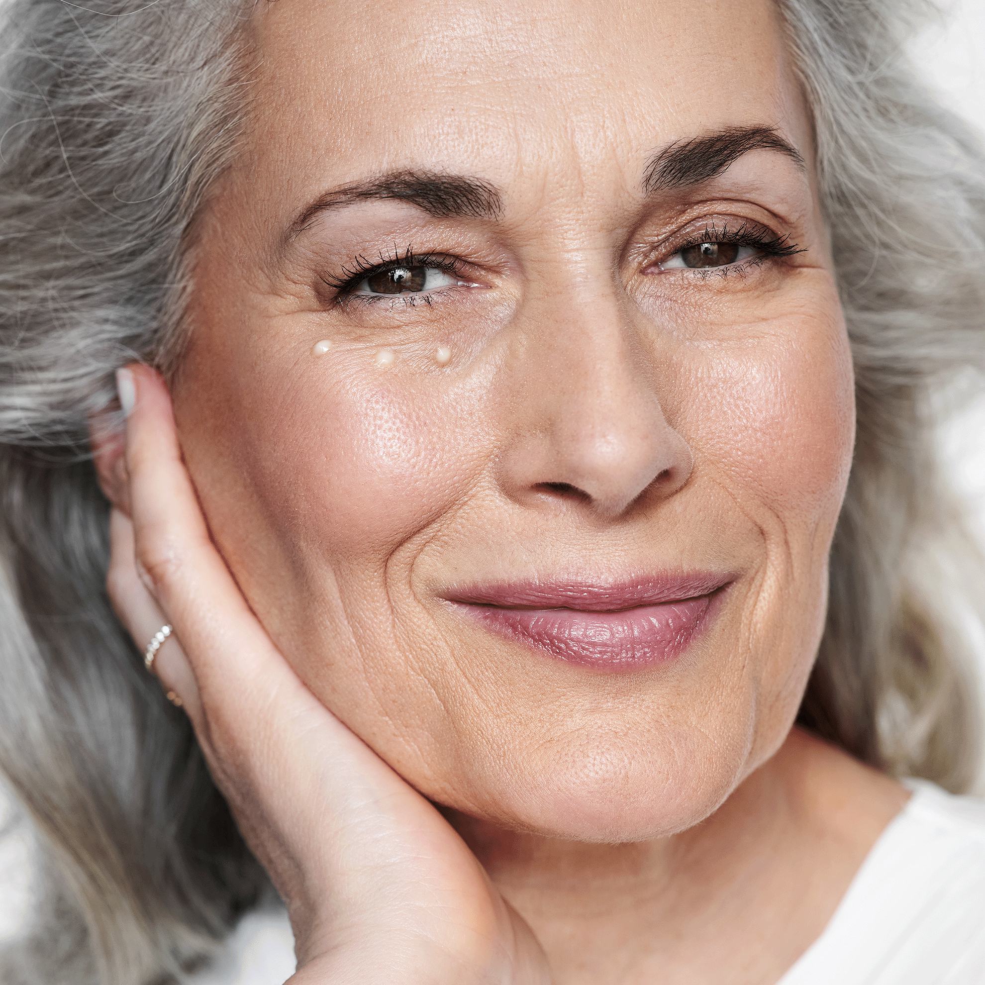 moteris, laikanti ranką ant veido