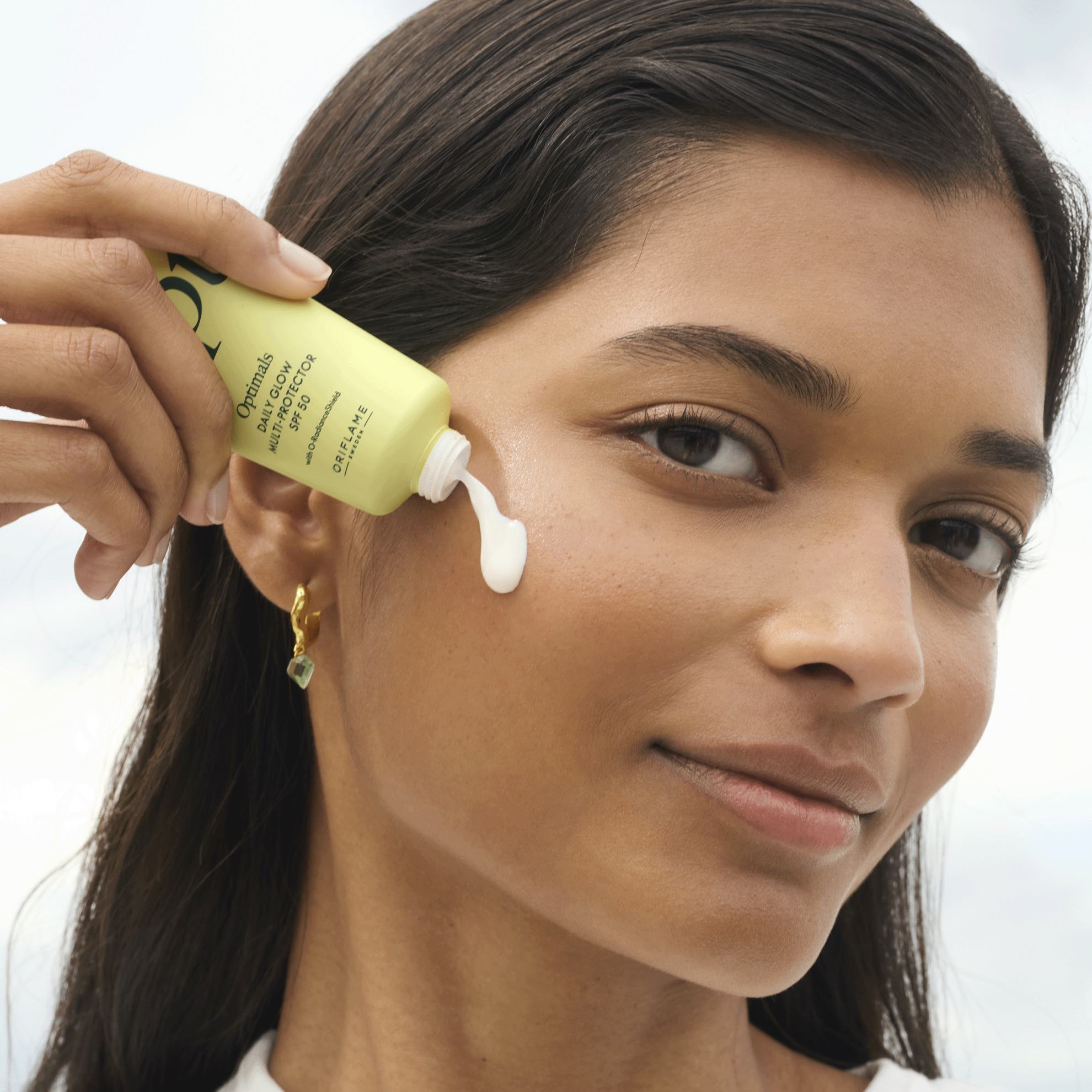 женщина наносит крем на лицо