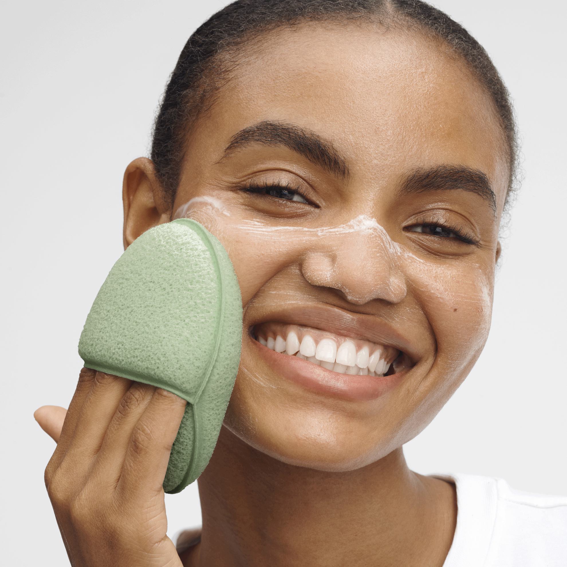 женщина наносит губку на лицо