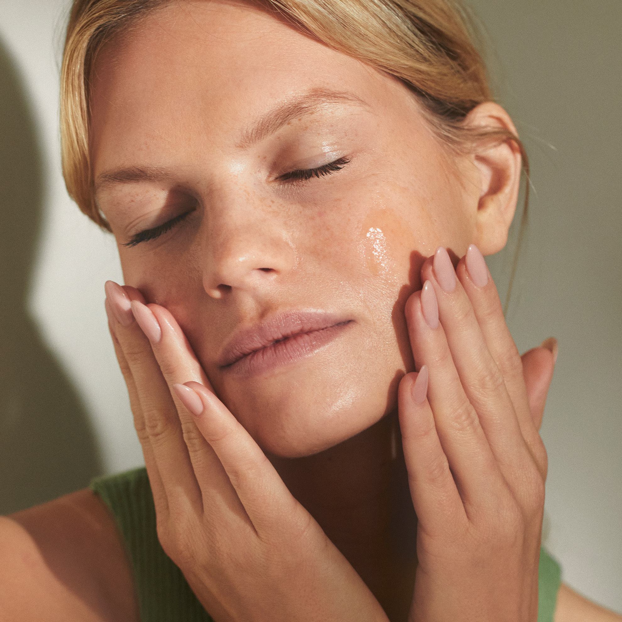 Gözleri kapalı, yüzünü elleriyle tutan bir kadın