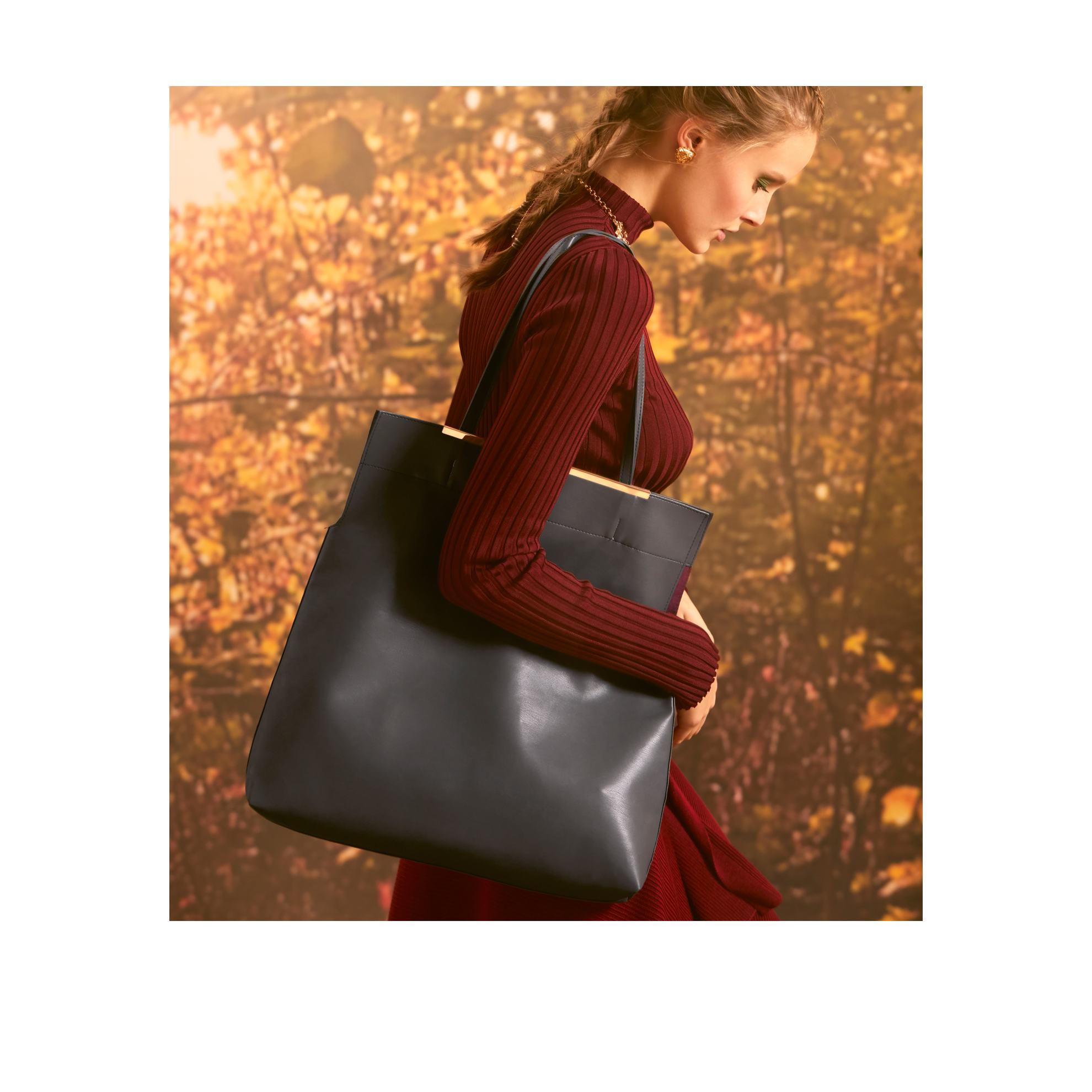 Una mujer con un vestido rojo sosteniendo un bolso negro.