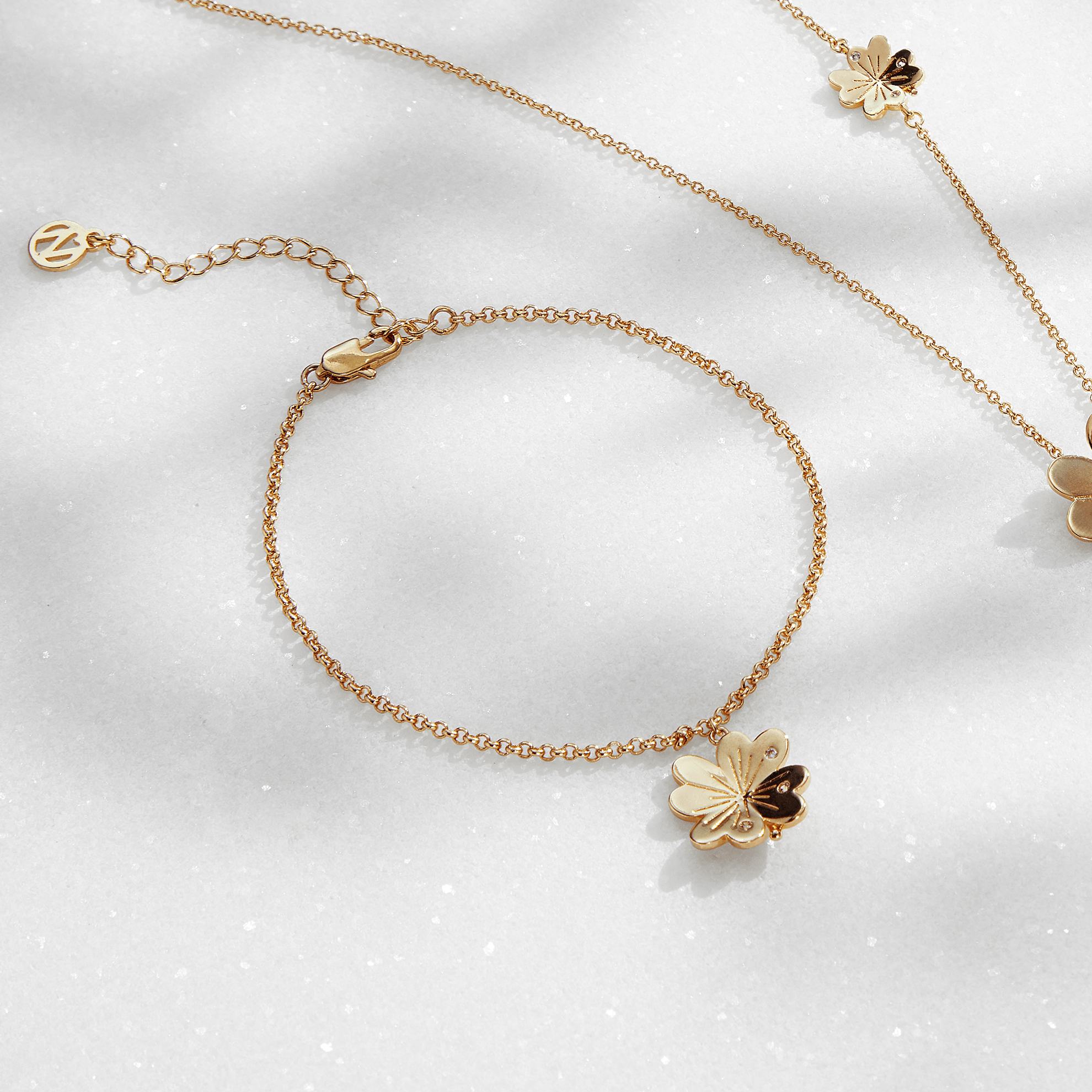 Un collar de oro con flores y una mariposa.