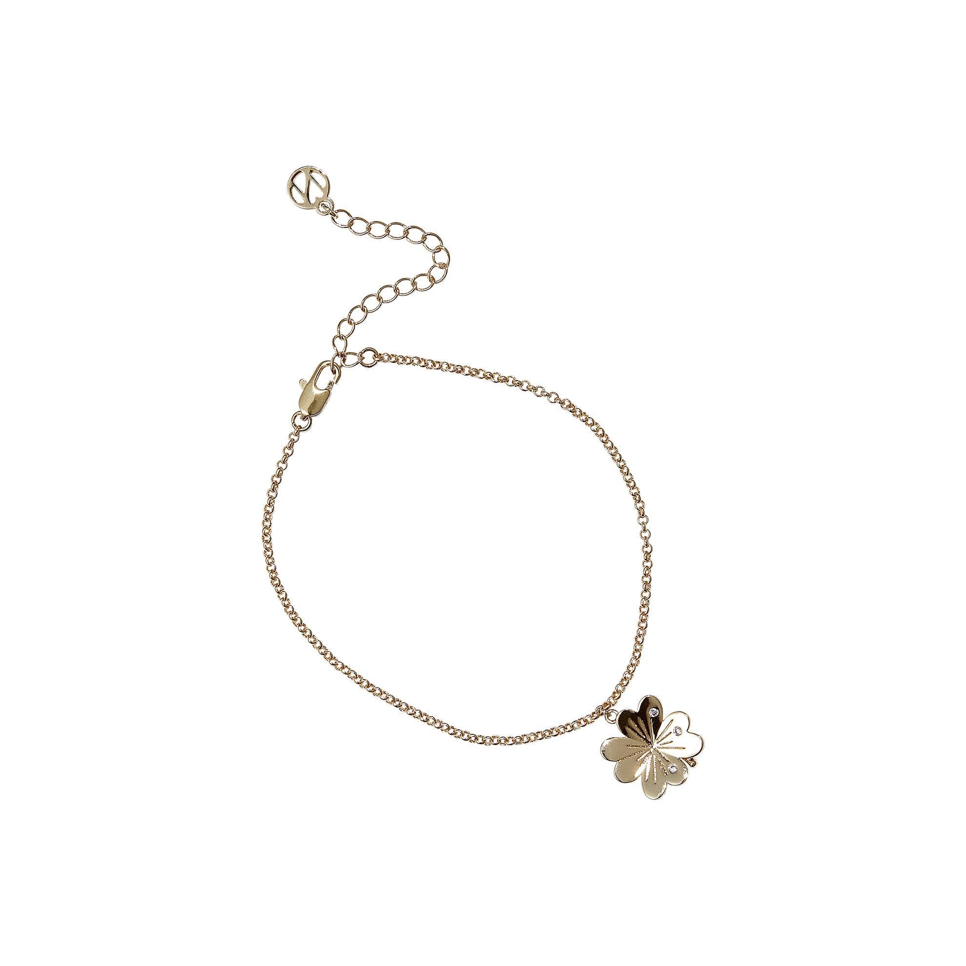 Una pulsera de oro con un dije en forma de trébol.