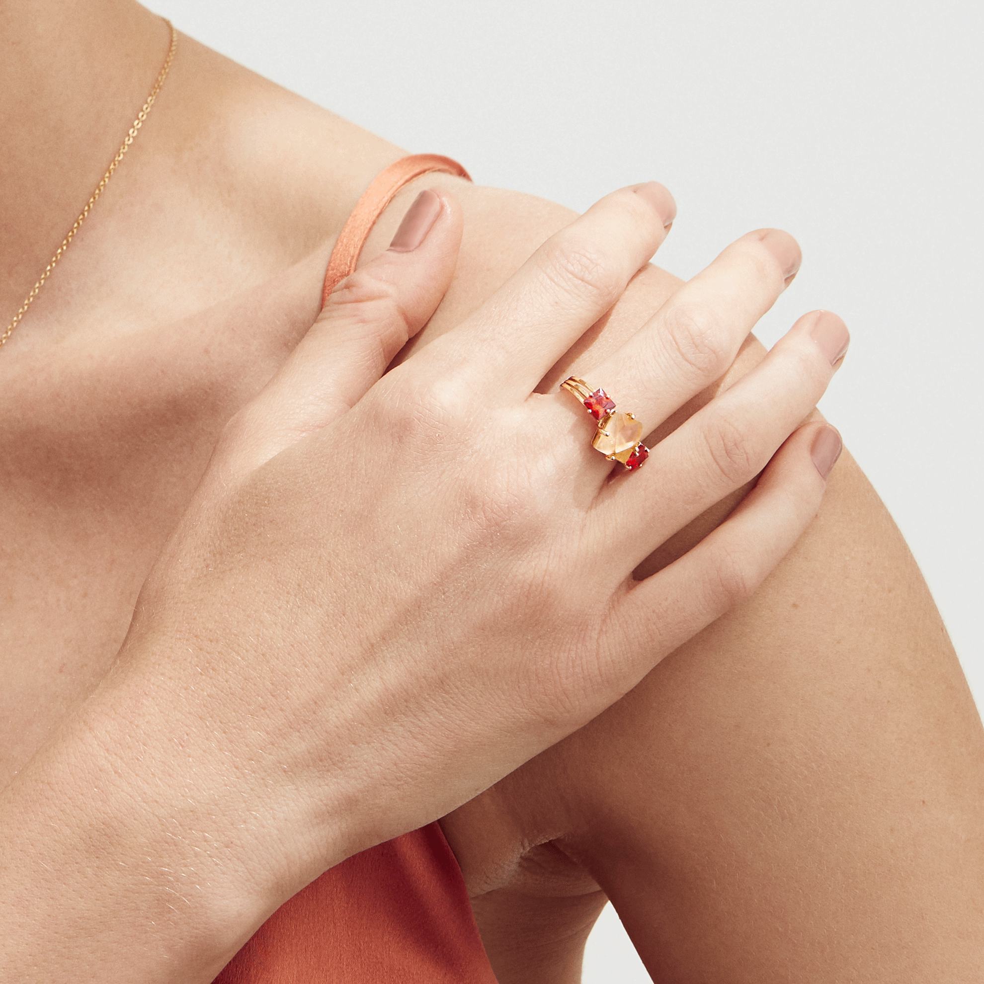 a woman wearing a ring and necklace