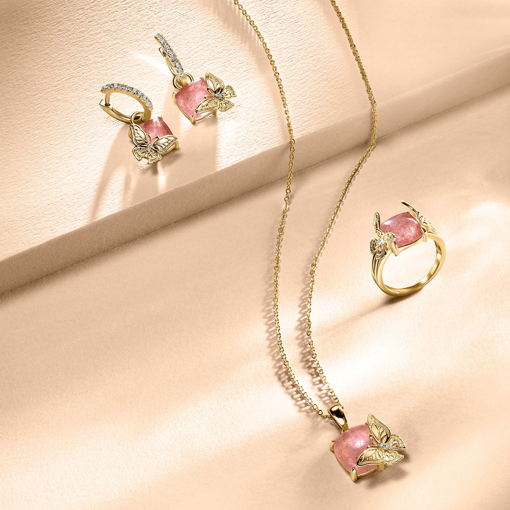 Un collar y pendientes de oro con piedras rosas.