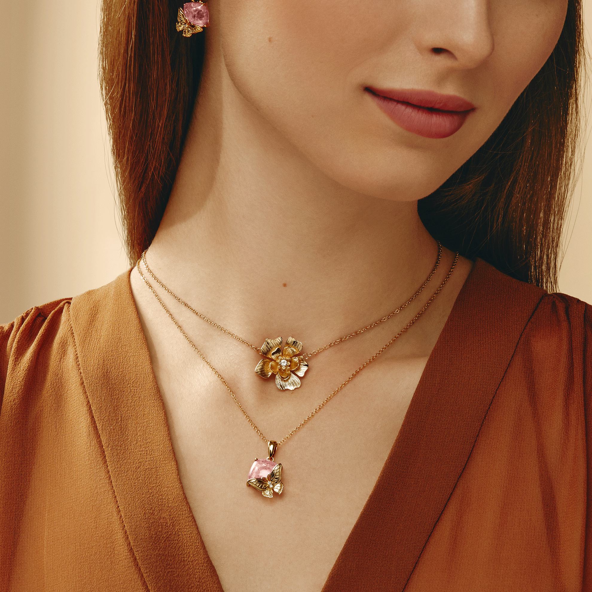 a woman wearing a gold necklace and earrings