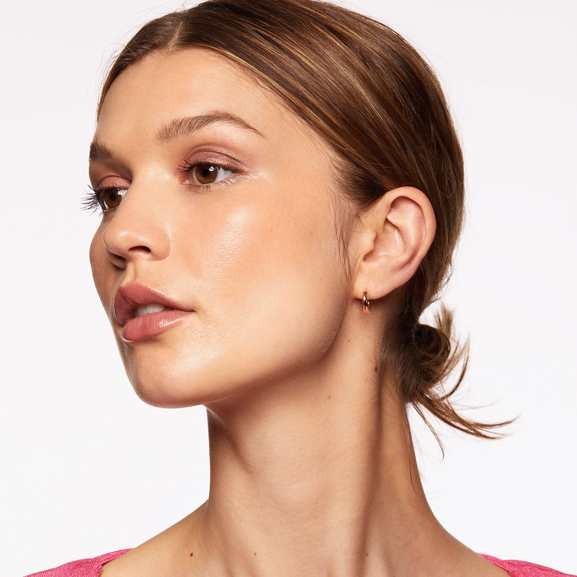 Una mujer con coleta y maquillaje.