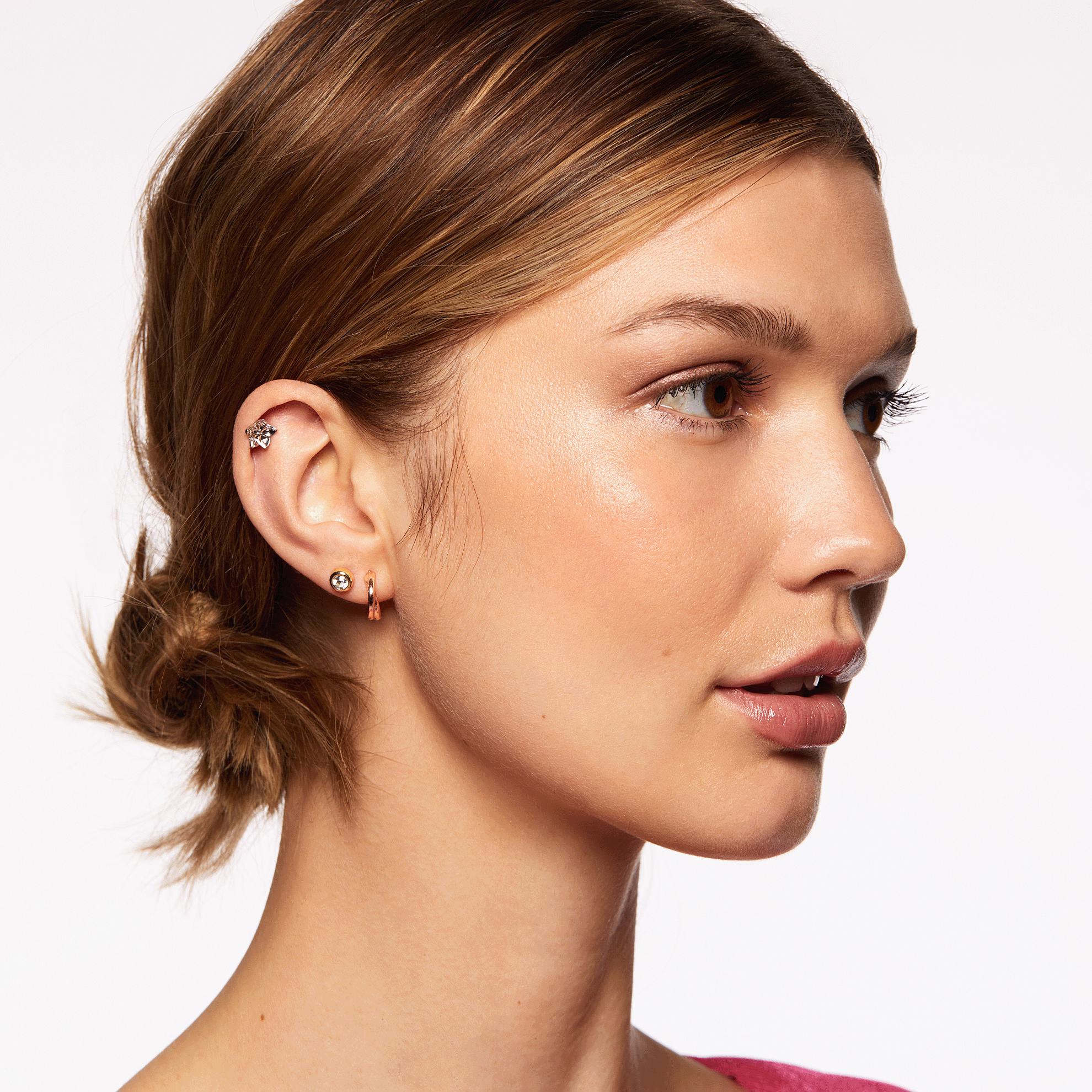 Una mujer con coleta y pendientes.