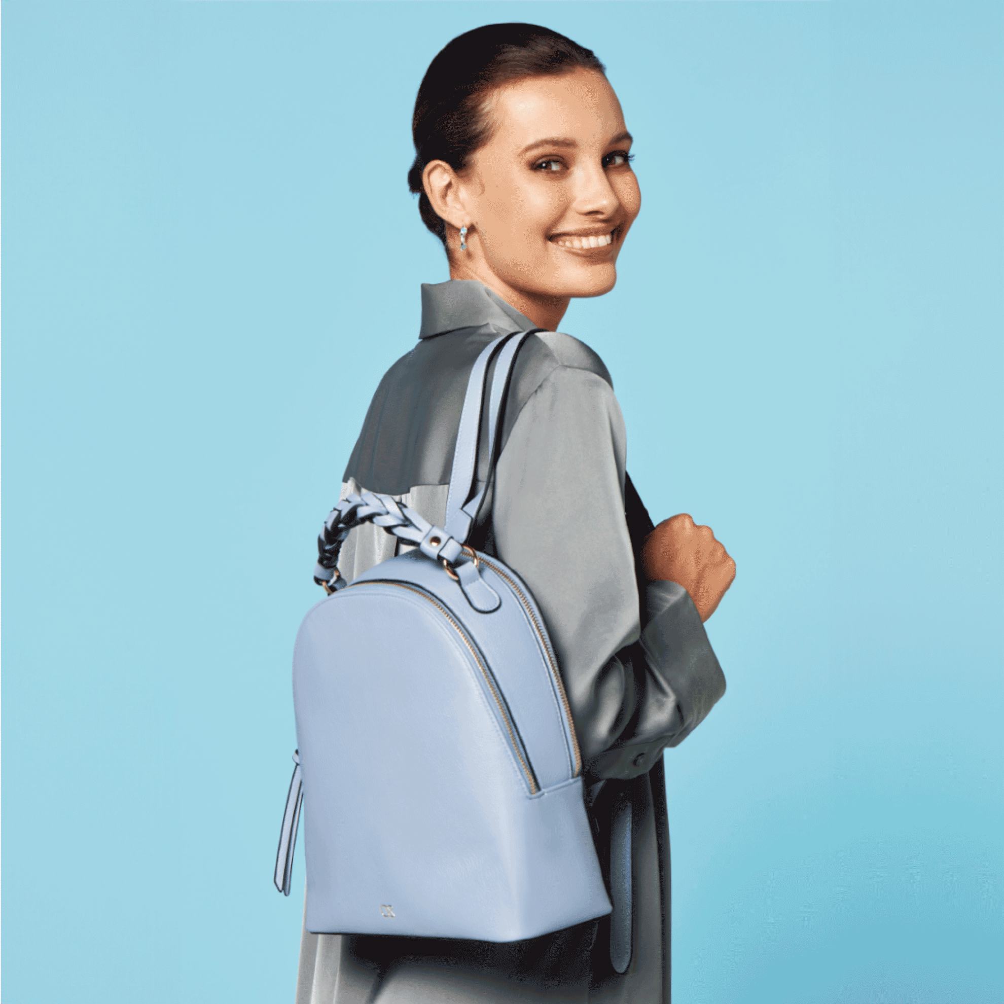 mavi paltar geyinmiş və mavi sırt çantası tutan bir qadın