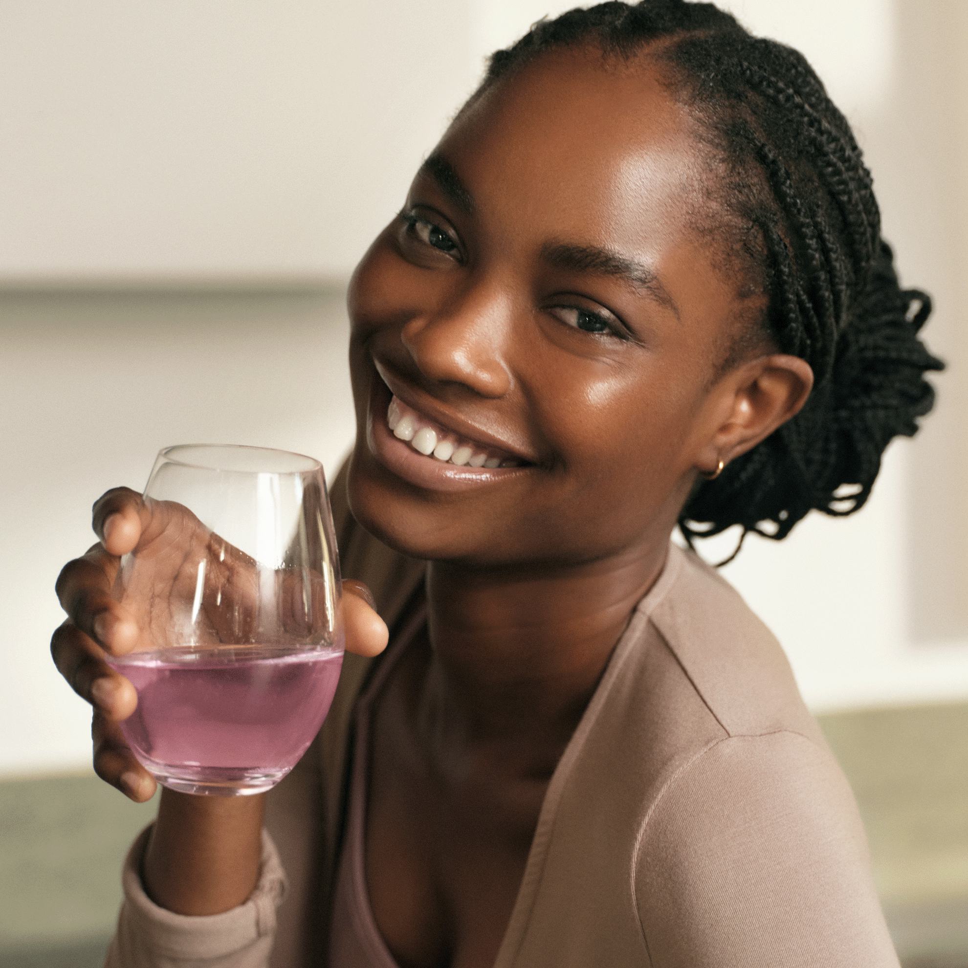 naine, kes hoiab klaasi roosat vedelikku