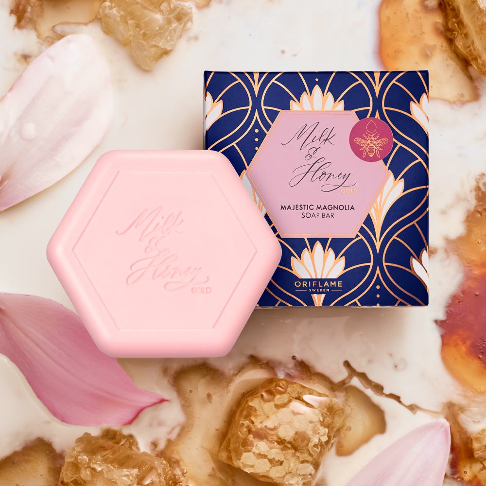 Una caja con un recipiente rosa junto a una caja azul con pétalos de flores dorados y blancos.