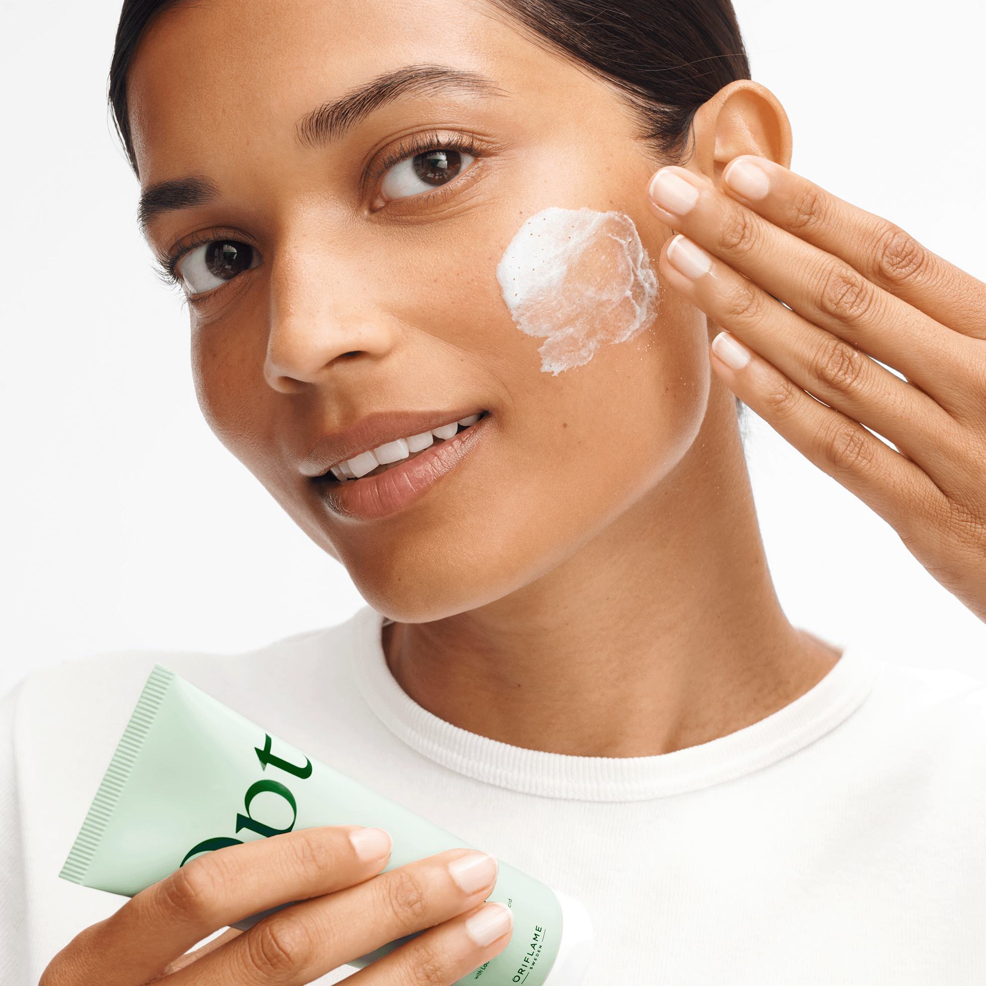 een vrouw die crème op haar gezicht aanbrengt