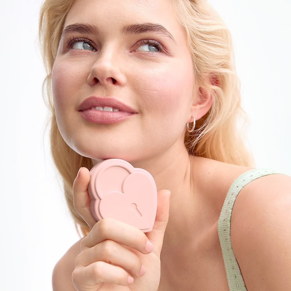 uma mulher segurando uma caixa rosa em forma de coração