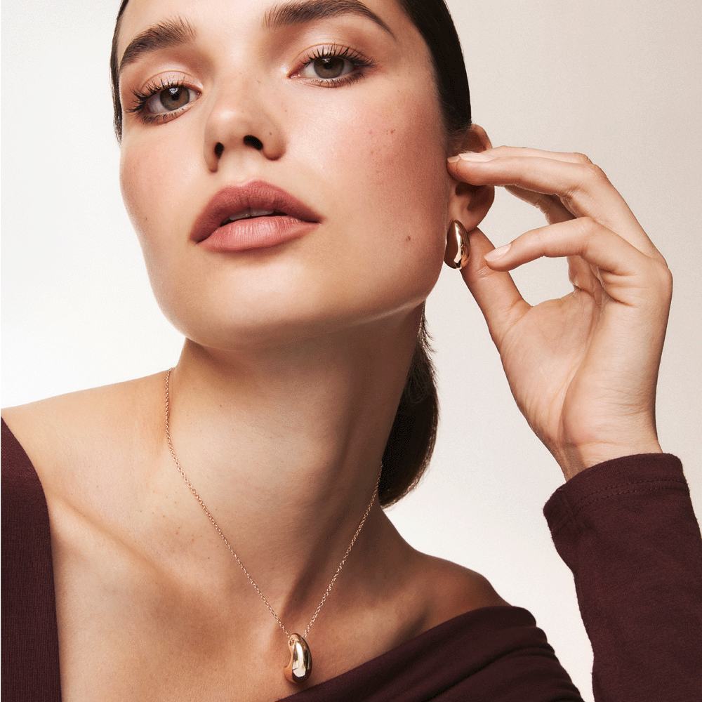 nyaklánccal és fülbevalóval díszített nő