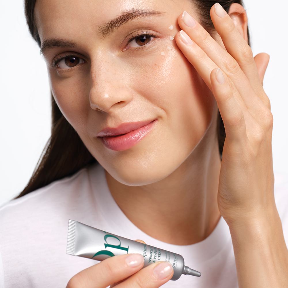 ženska, ki si na obraz nanaša kremo