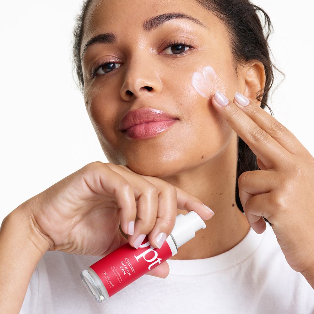 ženska, ki si na obraz nanaša kremo