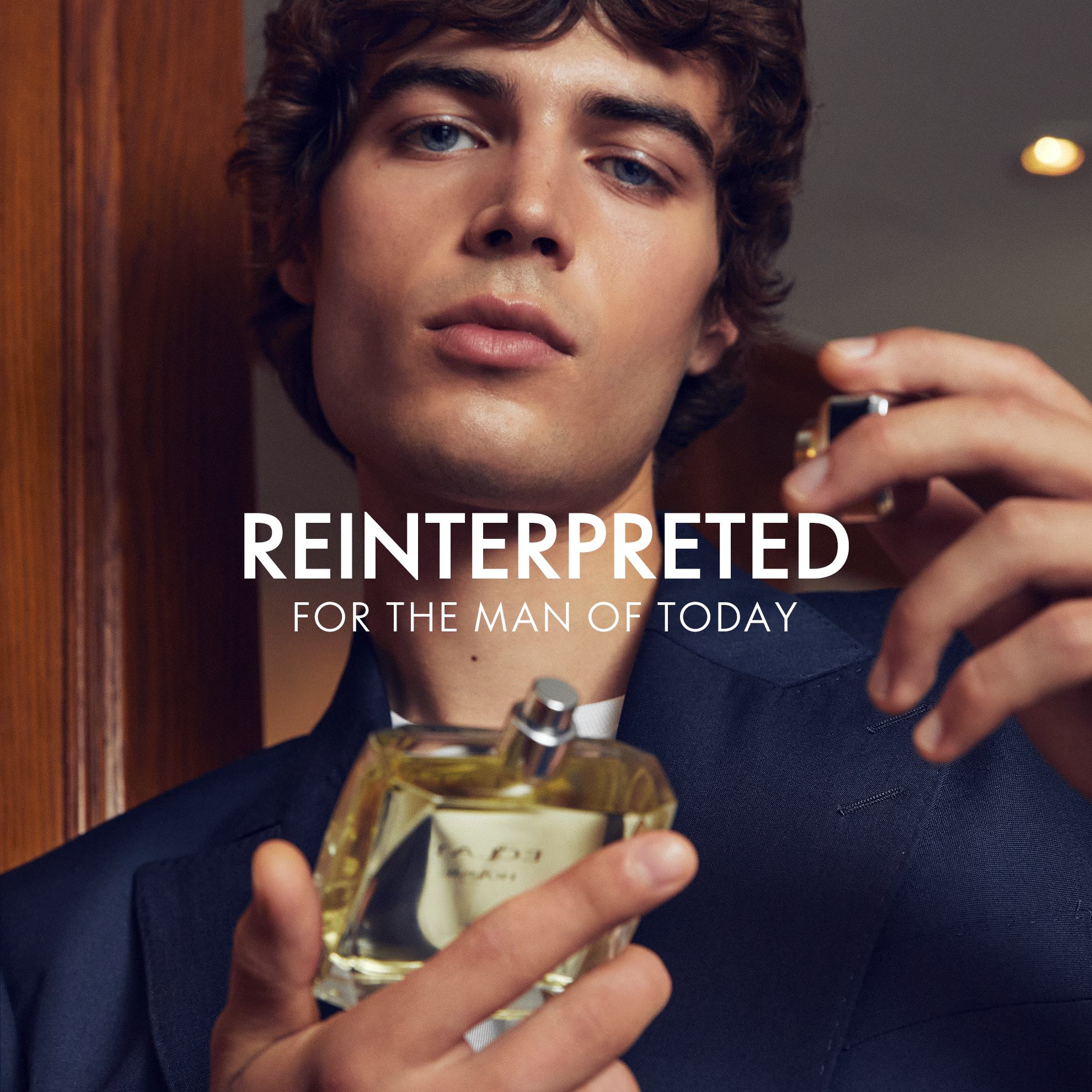 a man holding a bottle of perfume