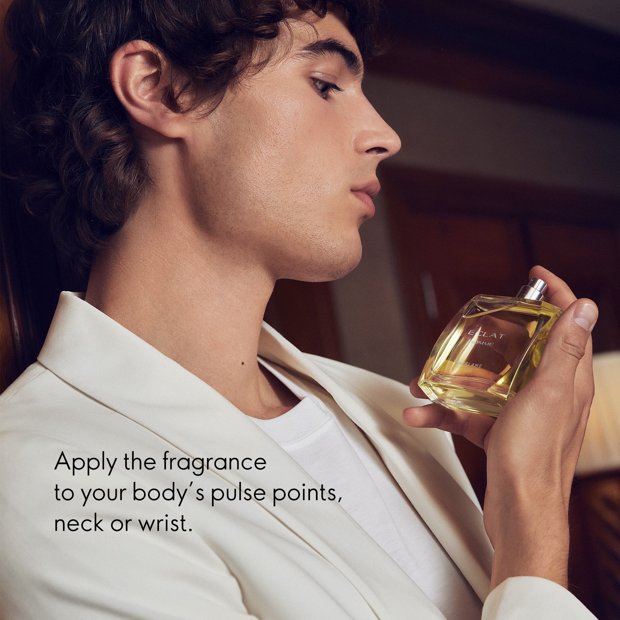 a man holding a bottle of perfume