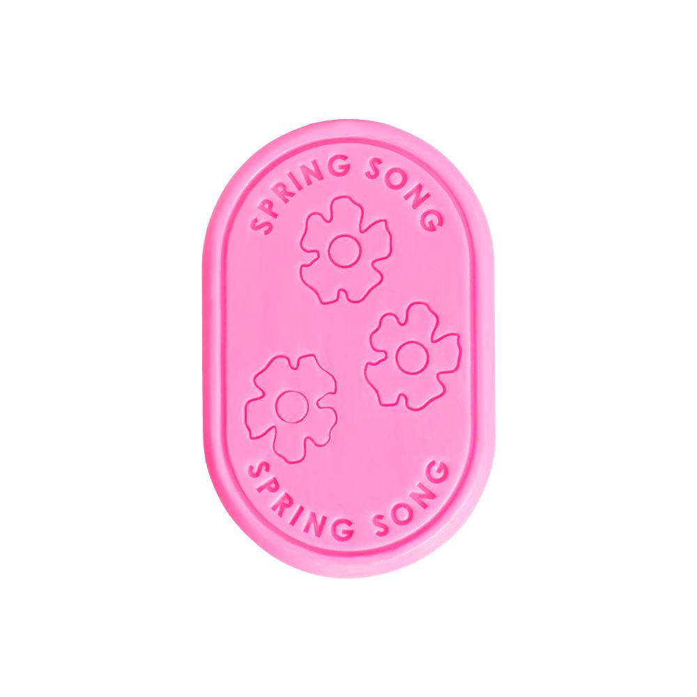 un obiect dreptunghiular roz cu flori și text