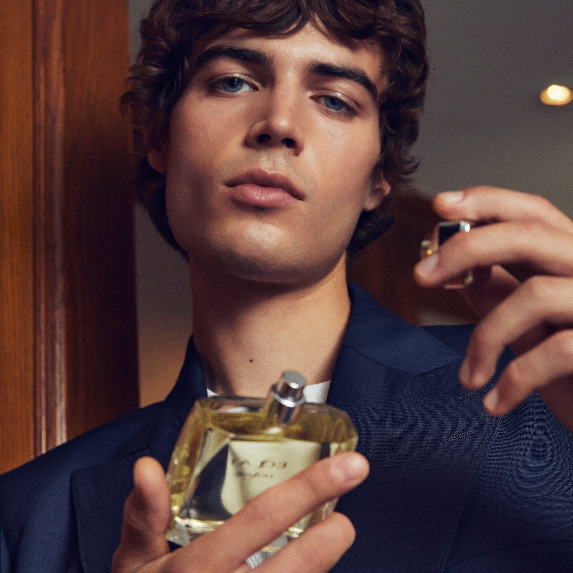 un homme tenant un flacon de parfum