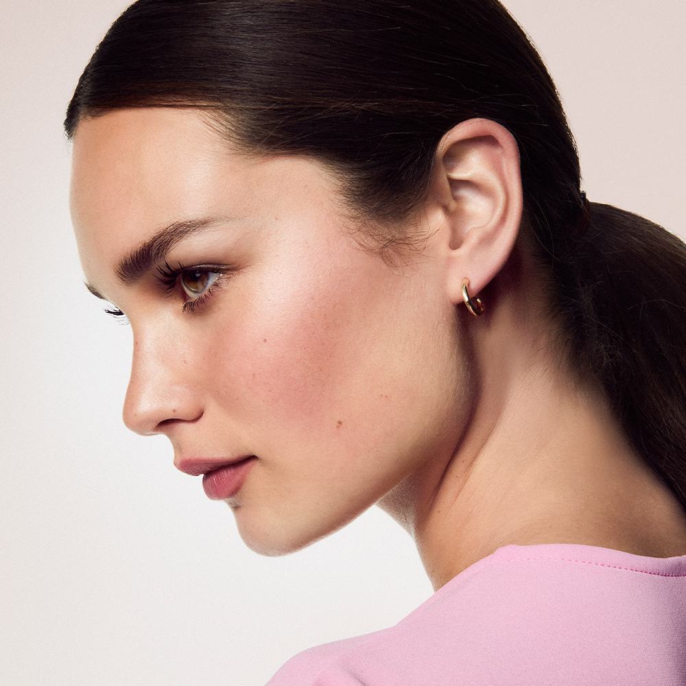 Žena s culíkem v růžovém tričku.