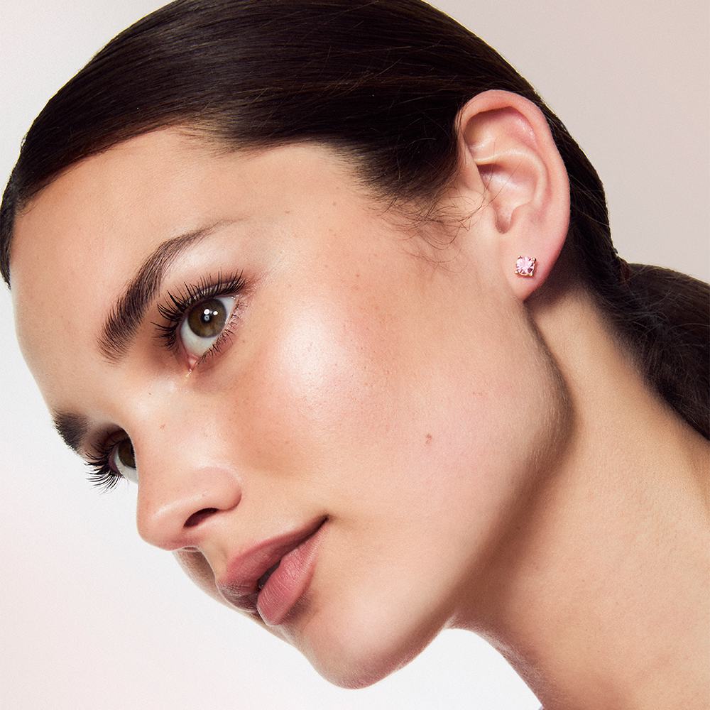 Žena s tmavými vlasy a culíkem, která má na sobě náušnice.