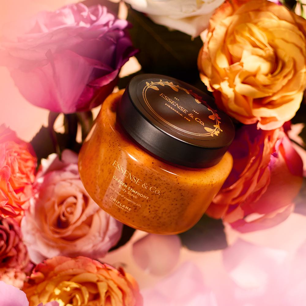 un borcan cu exfoliant pentru corp înconjurat de flori