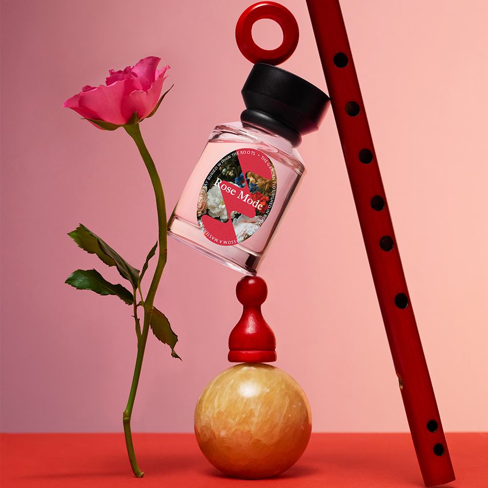 een flesje parfum en een bloem