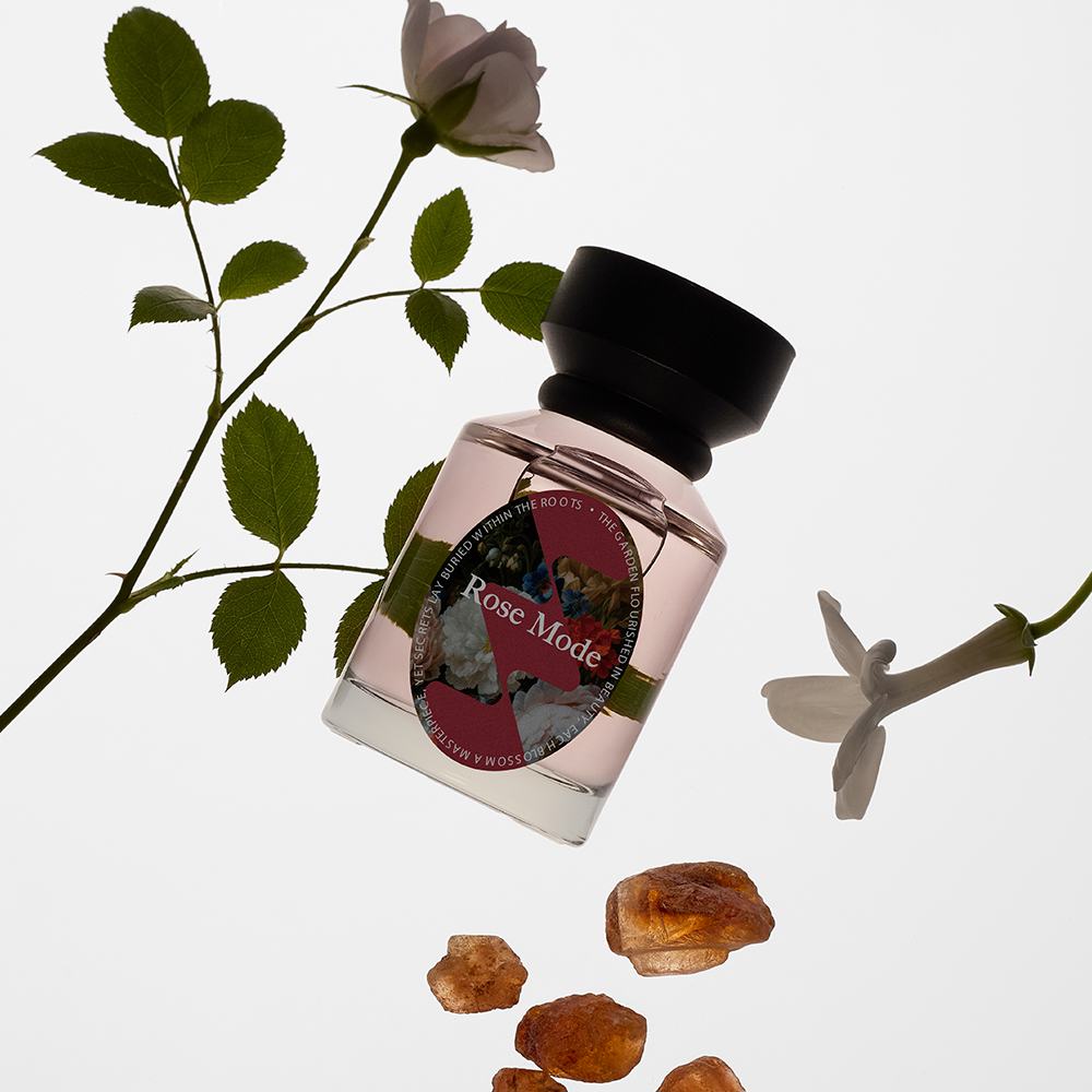 een flesje parfum naast enkele bruine kristallen