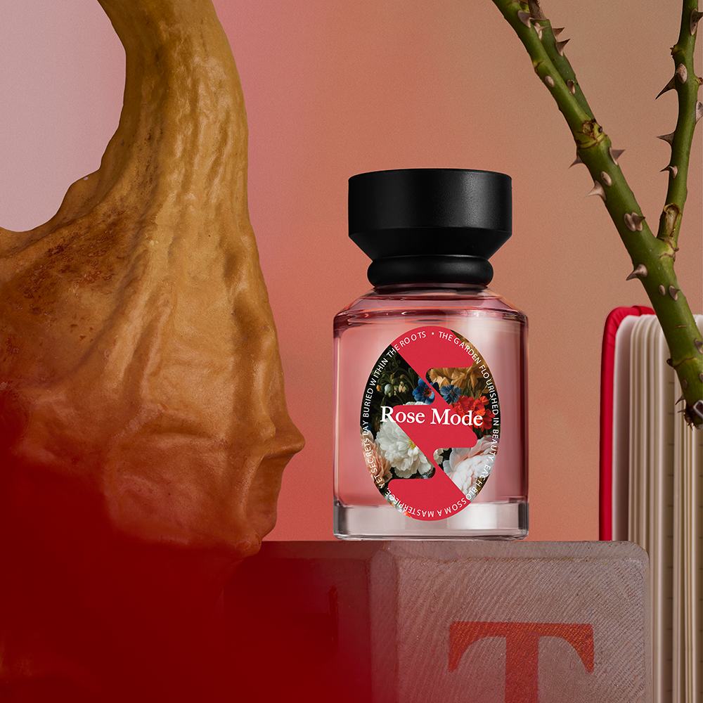 een flesje parfum naast een plant