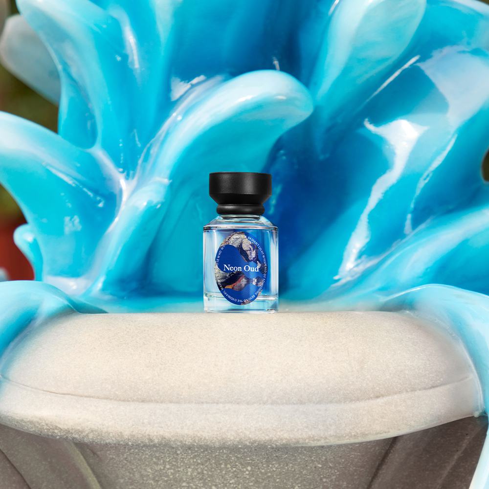 een klein flesje vloeistof op een blauw beeldhouwwerk