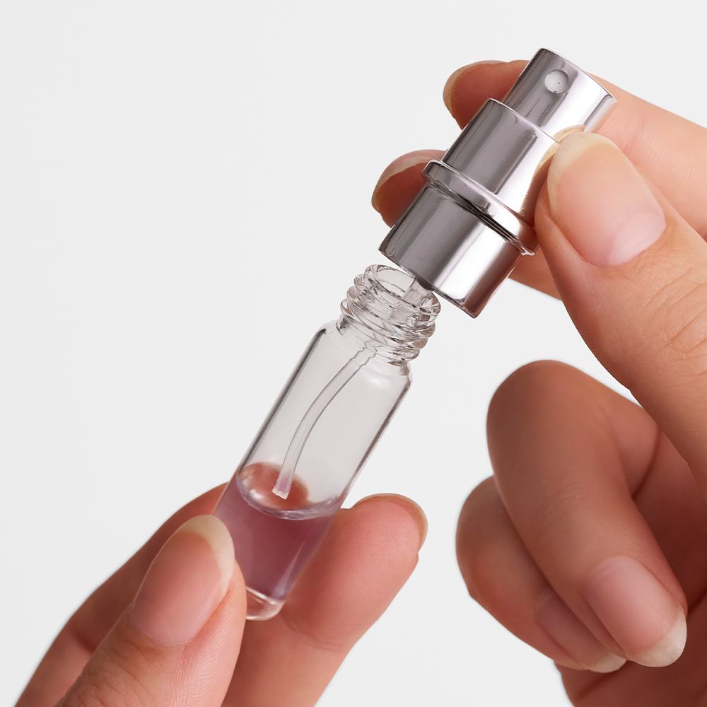 ένα άτομο που κρατά ένα μικρό μπουκαλάκι άρωμα