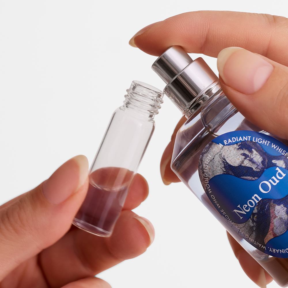 ένα χέρι που κρατά ένα μικρό μπουκαλάκι άρωμα