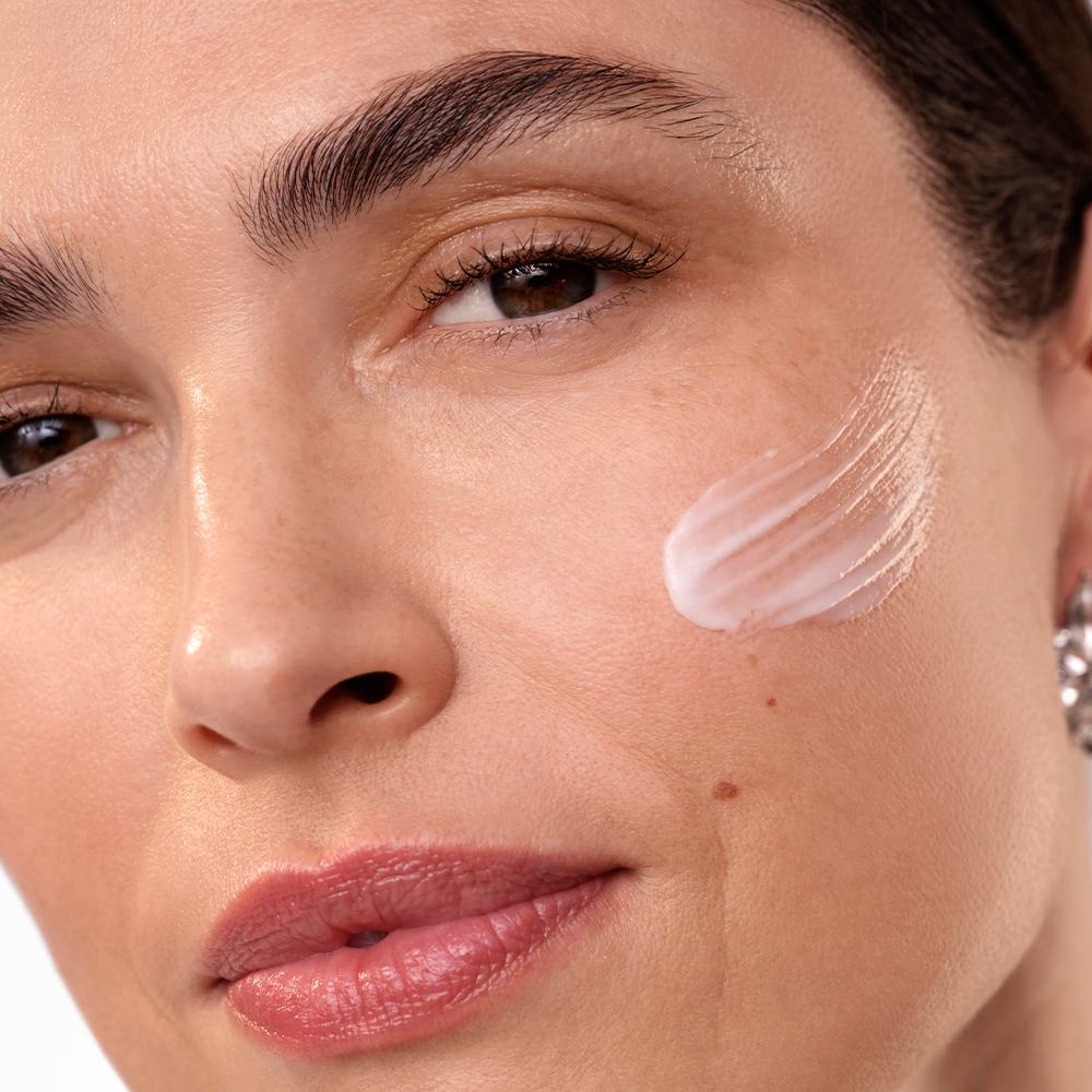 een vrouw met crème op haar gezicht